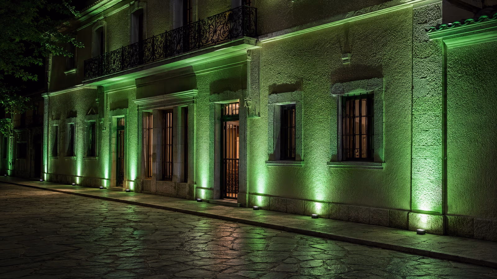 Historic building façade illuminated with green architectural uplighting