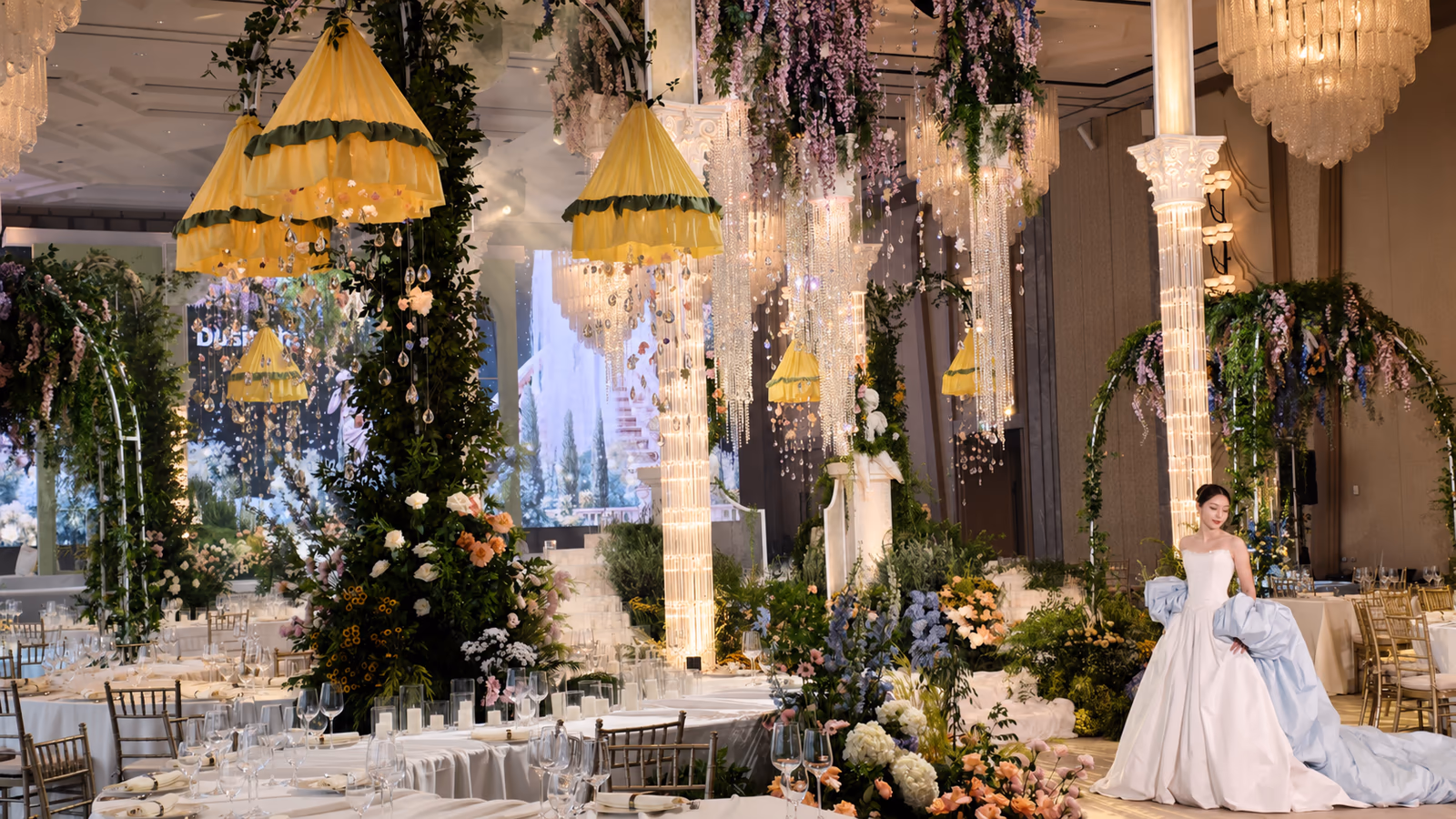 Elegant wedding banquet hall with warm decorative uplighting and illuminated columns